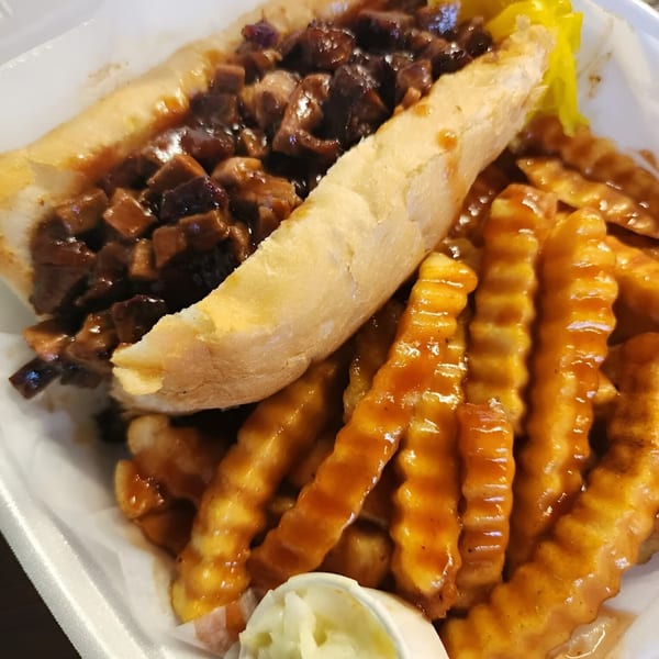 A No Sauce AZ Smokehouse BBQ brisket sandwich with crinkle-cut fries, coleslaw, and pickles.